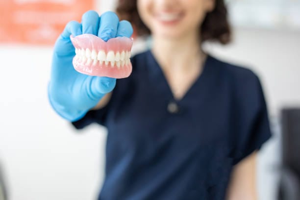 dental professional holding full dentures in Tucson, AZ