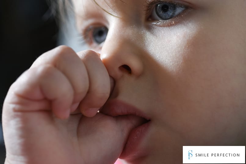 Close-up of a child sucking their thumb, highlighting the need for thumb-sucking deterrent solutions.